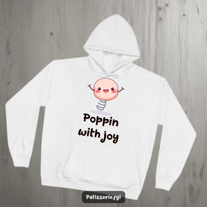 Funny hoodie adorned with a cheerful macaron bouncing energetically on a spring, perfect for staying warm and happy.